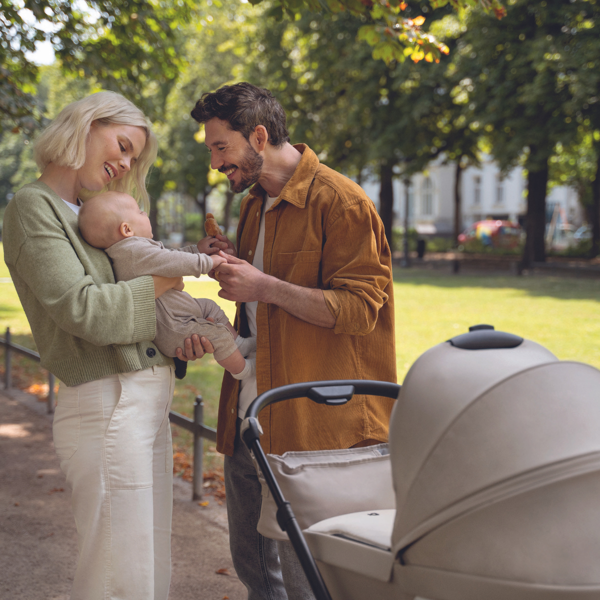 Eltern mit Baby nutzen den Kinderwagen #farbe_kängurubeige