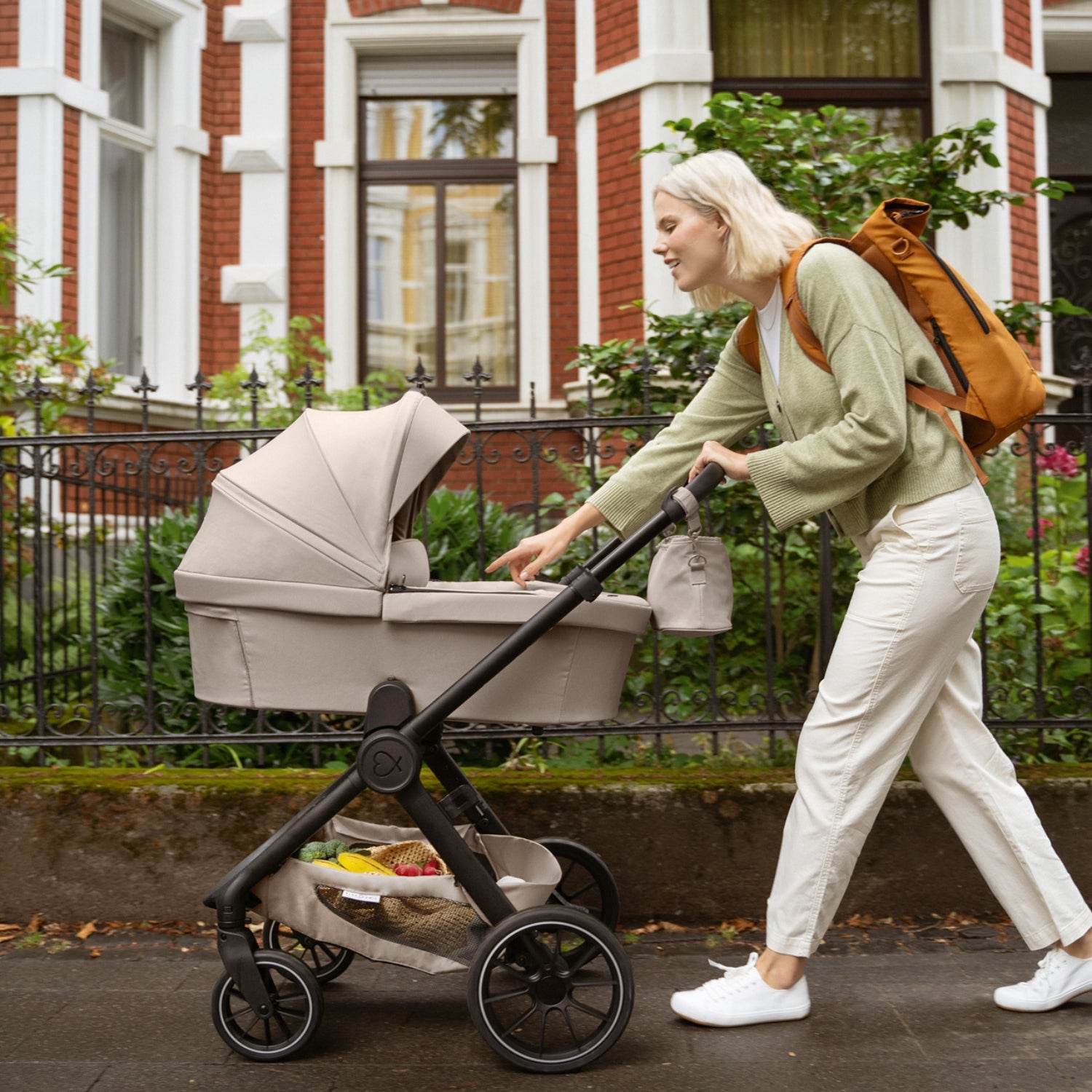 Frau mit Kinderwagen und Rucksack #farbe_kängurubeige