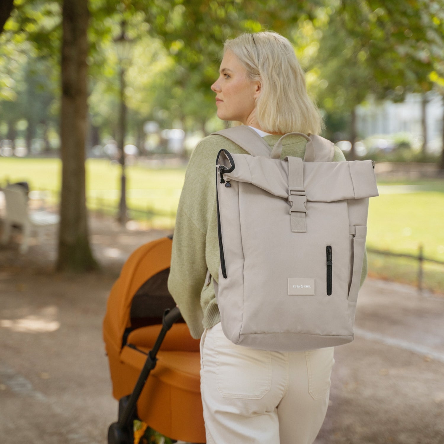 Frau mit Rucksack und Kinderwagen #farbe_kängurubeige
