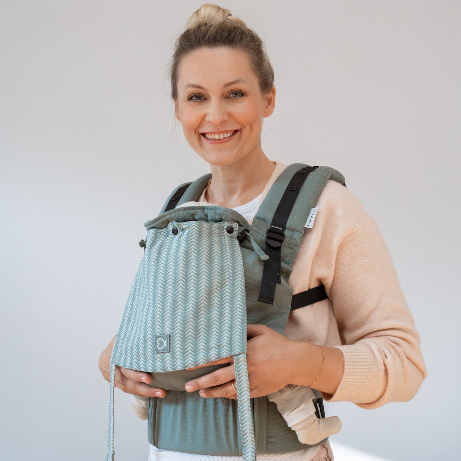 Frau mit Kind in Babytrage #farbe_arrow