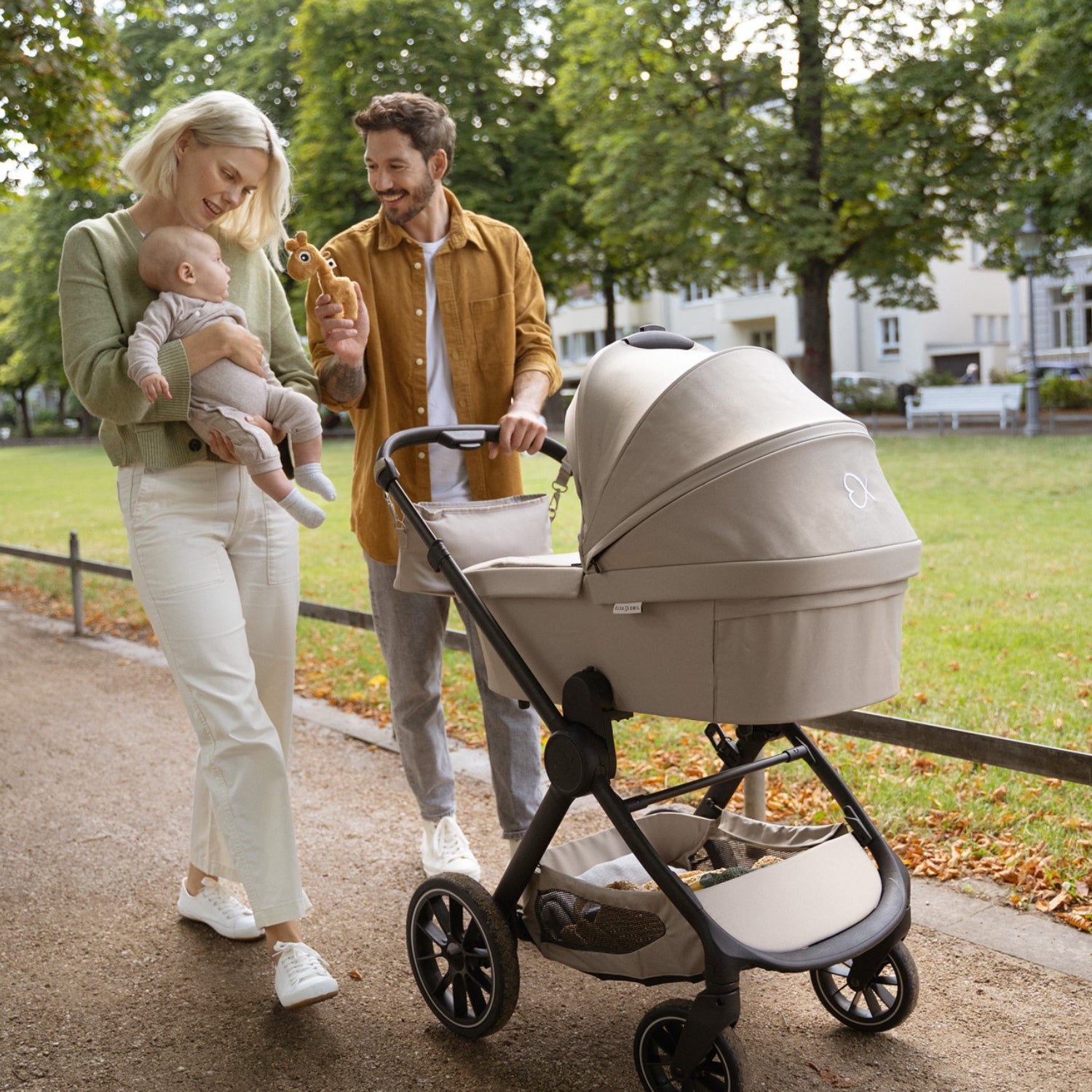 Eltern mit Kind und Kinderwagen beim Spaziergang #farbe_kängurubeige