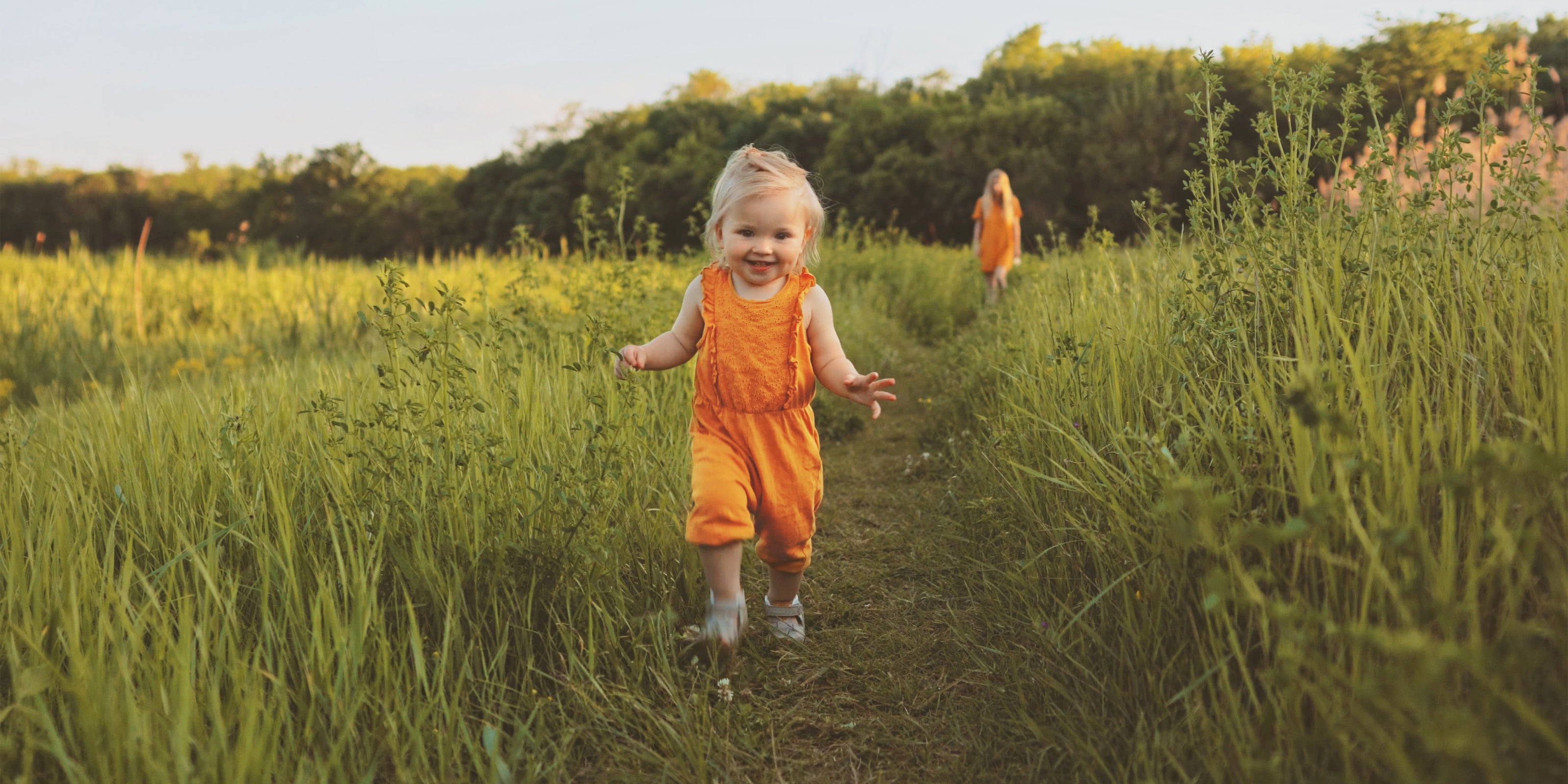 Kind läuft auf einer Wiese