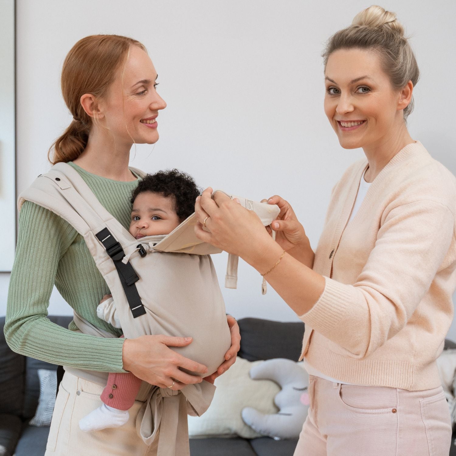Hebamme Maike Campen demonstriert die Halfbuckle in #kängurubeige mit einem Baby am Modell