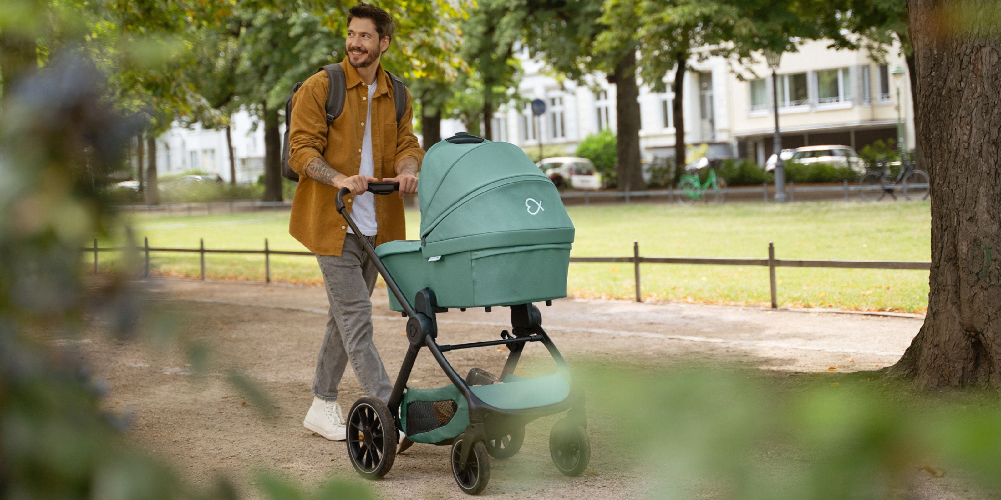 Vater spaziert mit dem ELSA & EMIL Kinderwagen #farbe_krokodilgrün